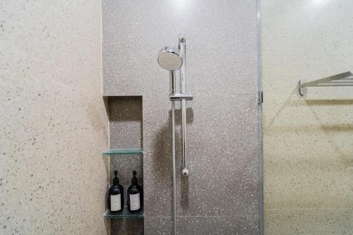 a shower with two bottles of wine in a bathroom at Alyxia 1 Bedroom Apartment in Central Seminyak in Seminyak
