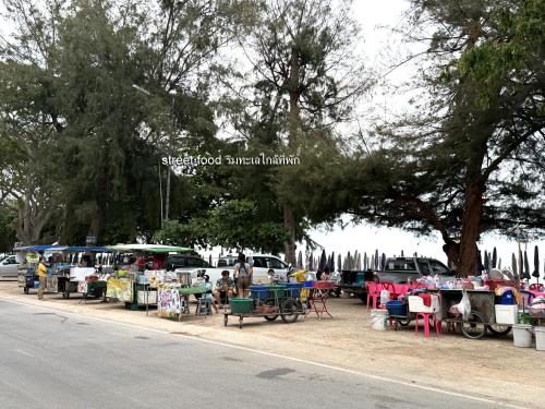 a street food market with tables and chairs on the side of the road at Brown House Cha am in Cha Am