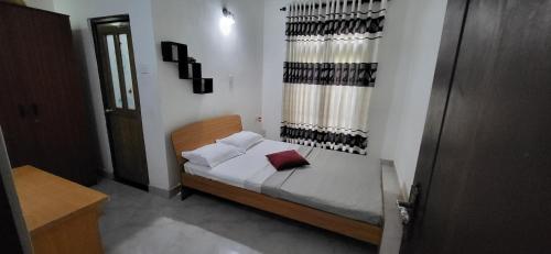 a bedroom with a bed with white sheets and pillows at Villa De Wick's in Kimbulapitiya