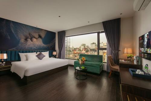 a hotel room with a bed and a green couch at Westlake Pearl Suites & Spa 70 Xuan Dieu - By Pegasy Group in Hanoi