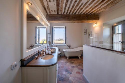 a bathroom with a tub and a sink and a bath tub at La Bastide in Oppède