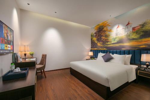 a bedroom with a white bed and a painting on the wall at Westlake Pearl Suites & Spa 70 Xuan Dieu - By Pegasy Group in Hanoi