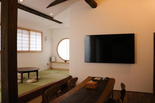 a living room with a flat screen tv on the wall at Ito Ryokan in Tokyo