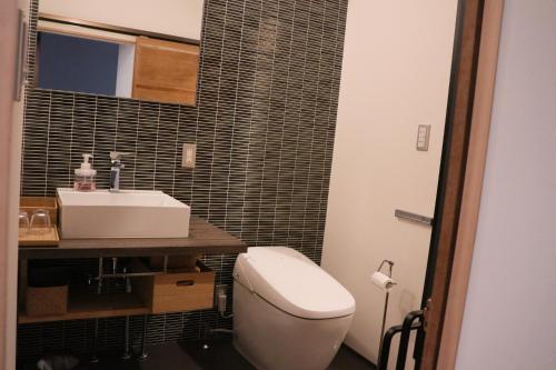 a bathroom with a white toilet and a sink at Ito Ryokan in Tokyo