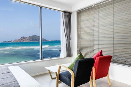 a living room with a view of the ocean at Here Now pension in Jeju