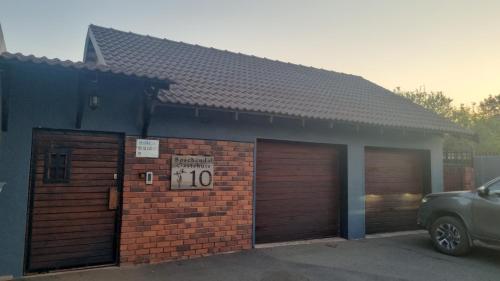 un edificio con dos puertas de garaje con un cartel. en Boschendal Guesthouse, en Kimberley