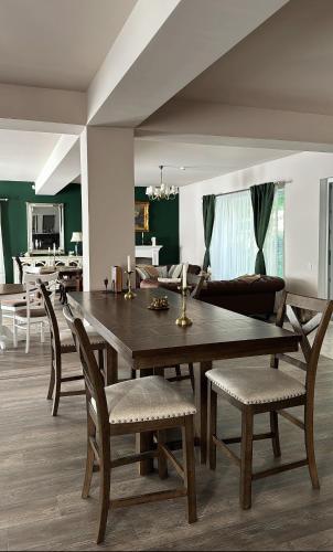 a dining room with a wooden table and chairs at Forest House Retreat in Curtea de Argeş