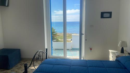 a bedroom with a bed and a view of the ocean at Casa Direttamente sul mare in Marina di Mancaversa
