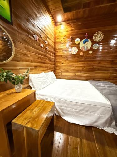 a bedroom with a bed and a wooden wall at Cô Tô Homestay 368 in Chung Cap