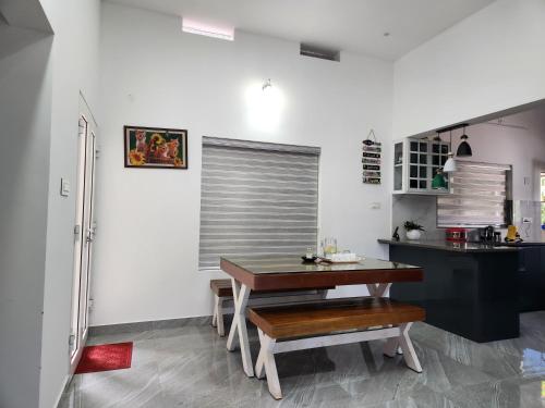 a kitchen with a wooden table and a dining room at Uthuppan's HolidayHome in Ūdumbanshola