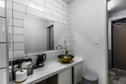 a bathroom with a sink and a mirror at Here Now pension in Jeju