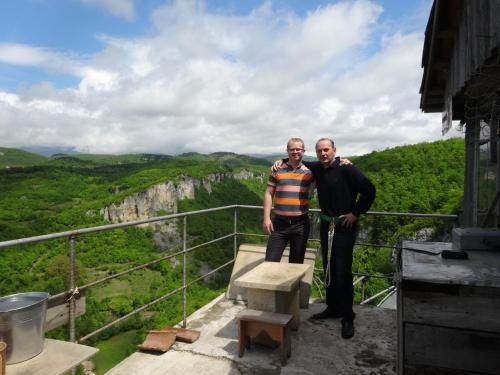 two men standing on the edge of a balcony of a mountain at Giorgi's Homestay in Kutaisi