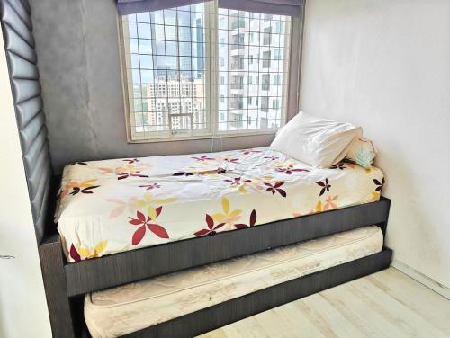 a small bed in a room with a window at Strategic 3BR Thamrin Residence Near Pl & GI by 2ndHome in Jakarta
