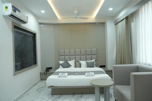 a hotel room with a bed and a couch at Hotel M Town in Ahmedabad