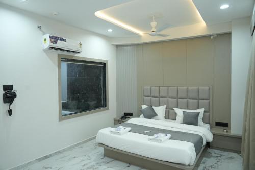 a hotel room with a bed and a window at Hotel M Town in Ahmedabad