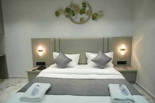 a bedroom with a large bed with two towels on it at Hotel M Town in Ahmedabad