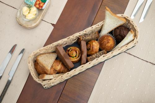 a basket filled with different types of bread on a table at Heritage Boutique by Seven Angels in Kandy
