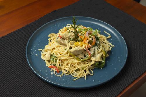 a blue plate of pasta with meat and vegetables at Heritage Boutique by Seven Angels in Kandy
