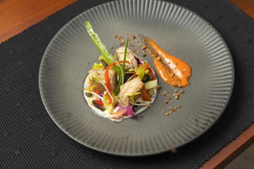 a plate with a salad and a carrot on it at Heritage Boutique by Seven Angels in Kandy
