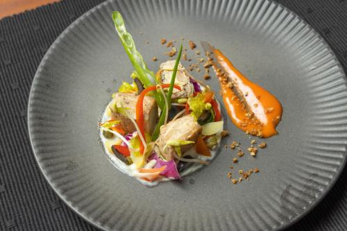 a white plate with a salad on a table at Heritage Boutique by Seven Angels in Kandy