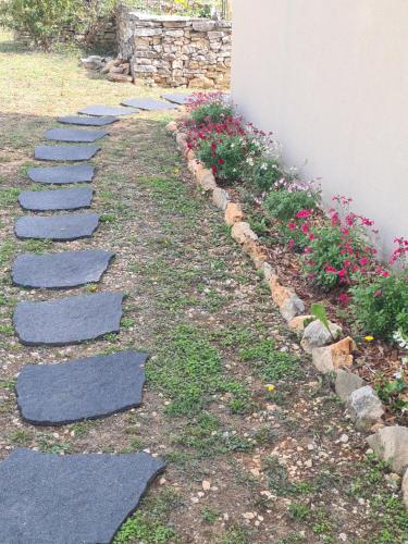 a stepping stone path in a garden with flowers at Le Petit Chêne in Orgnac-lʼAven