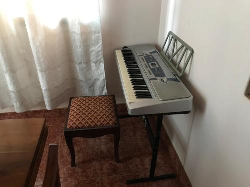 a piano sitting on a stool next to a chair at Kitonga Escape in Msaranga