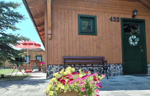 a building with a bench and flowers in front of it at Tatralandia Chatka SnoWiki in Liptovský Mikuláš