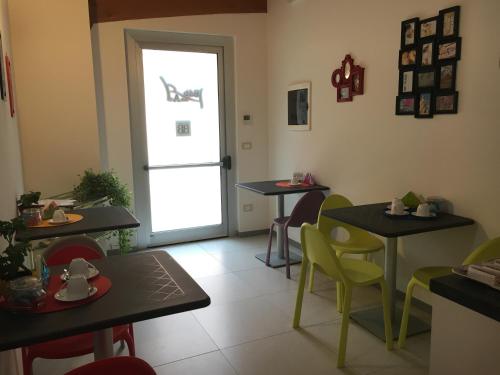 a dining room with tables and chairs and a door at B&B delle Arti in Preturo