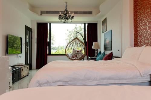 een slaapkamer met een groot wit bed en een raam bij 宜蘭馬堡莊園10-28人包棟民宿 in Shangwu