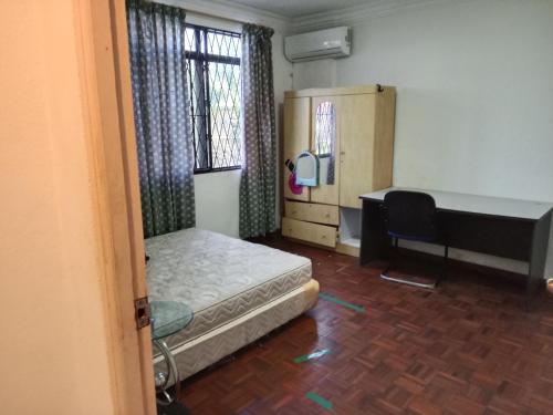 a bedroom with a bed and a desk and a table at PINTARMAN LUTONG VILLA Private Room with Shared Bathroom in Lutong