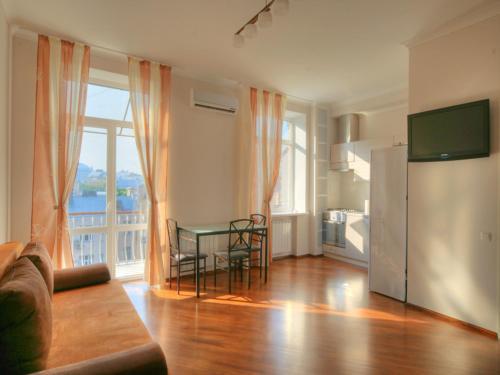 a living room with a couch and a table and a kitchen at BestKievApartment in Kyiv