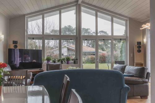 un salon avec un canapé et une grande fenêtre dans l'établissement Villa Uhaina Sérénité Océane, à Ondres