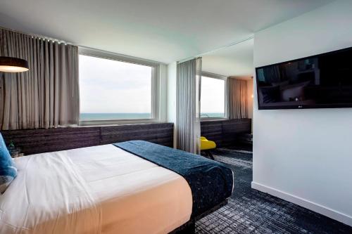 a hotel room with a bed and a flat screen tv at The Wade in Chicago
