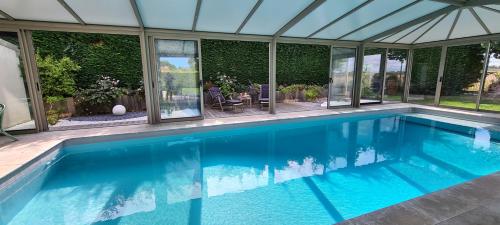 a swimming pool in a house at Villa 5*, mer à 3 mn, piscine intérieure à 28° in Gonneville-en-Auge
