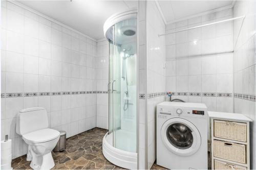 y baño con ducha y lavadora. en Hus i Verdal, en Verdal