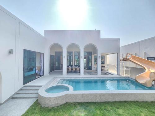 a house with a swimming pool and a slide at ภัทรา พูลวิลล่า ชะอำ Phattra Poolvilla Cha-am in Cha Am