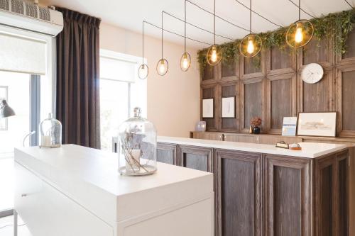 a kitchen with wooden cabinets and a white counter top at Grėjaus Namas in Kėdainiai