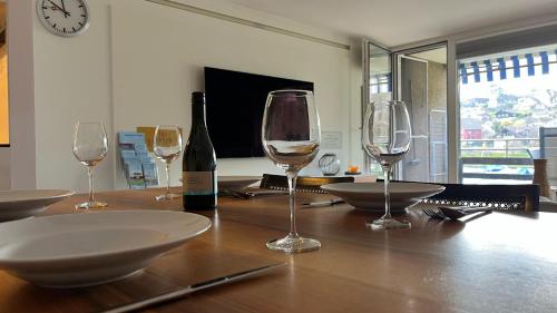 a table with wine glasses and a bottle of wine at Buchtoase in Spiez