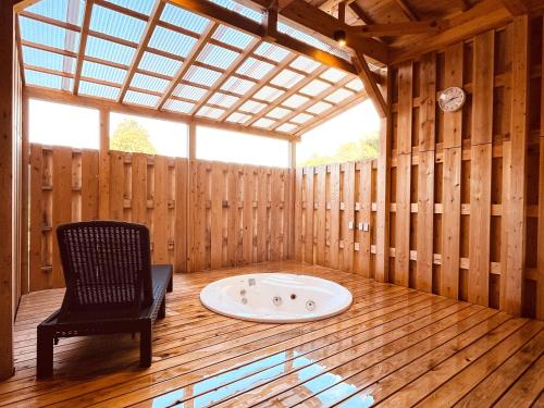 a sauna with a chair and a bath tub at 森の風 in Higashiizu