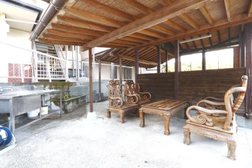 a group of chairs and a bench in a room at 森の風 in Higashiizu