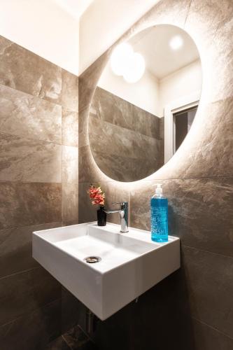 a bathroom with a white sink and a mirror at Boccaccio Apartment 2 in Ravenna