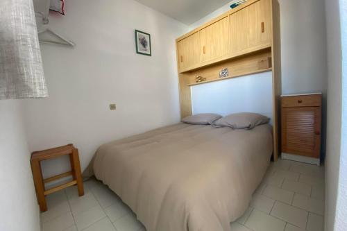 ein Schlafzimmer mit einem Bett und einem Holzschrank in der Unterkunft Softness of the shore on the port side in Frontignan