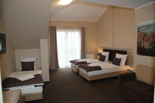 a hotel room with two beds and a window at Hotel Piast przy Zamku in Malbork