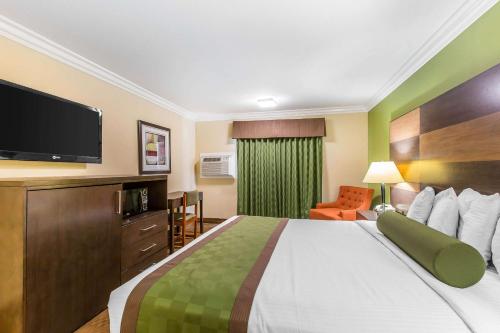 a hotel room with a large bed with a flat screen tv at Rodeway Inn & Suites Canyon Lake-Menifee West in Canyon Lake
