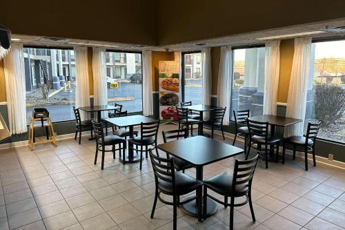 a restaurant with tables and chairs and windows at Quality Inn in Ashland
