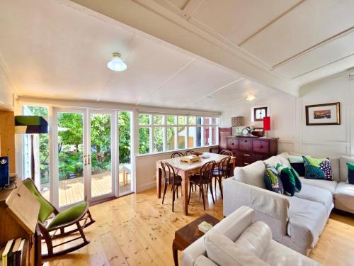 a living room with a couch and a table at Plum Blossom Cottage in Katoomba