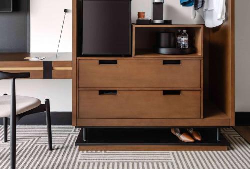 a wooden dresser with a television on top of it at Hotel Tupelo, a Wyndham Hotel in Tupelo