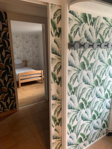 a hallway with a wall with a mural of leaves at Le Gîte de Buffetières in Saint-Romain-de-Popey
