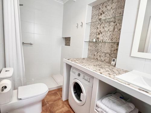 a white bathroom with a washer and dryer at La Casuca de Orejo - Monabri in Orejo