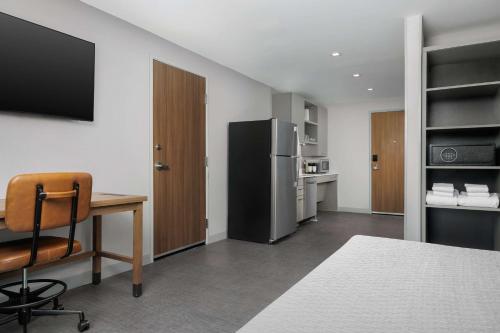 a room with a desk and a refrigerator at Homewood Suites By Hilton Newport Cincinnati in Newport